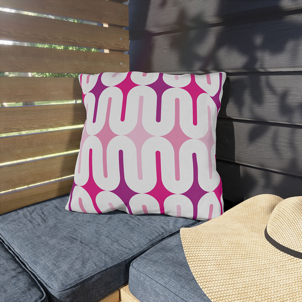 Mid Century Modern Pink Galaxie 18" Outdoor Pillow on a bench