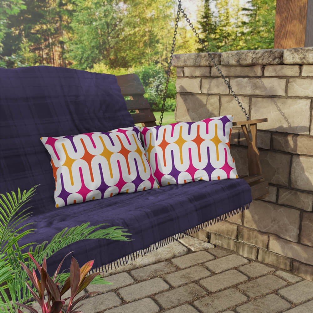 Two Mid Century Modern Orange Purple Galaxie 20" x 14" Outdoor Pillow on a swing bench