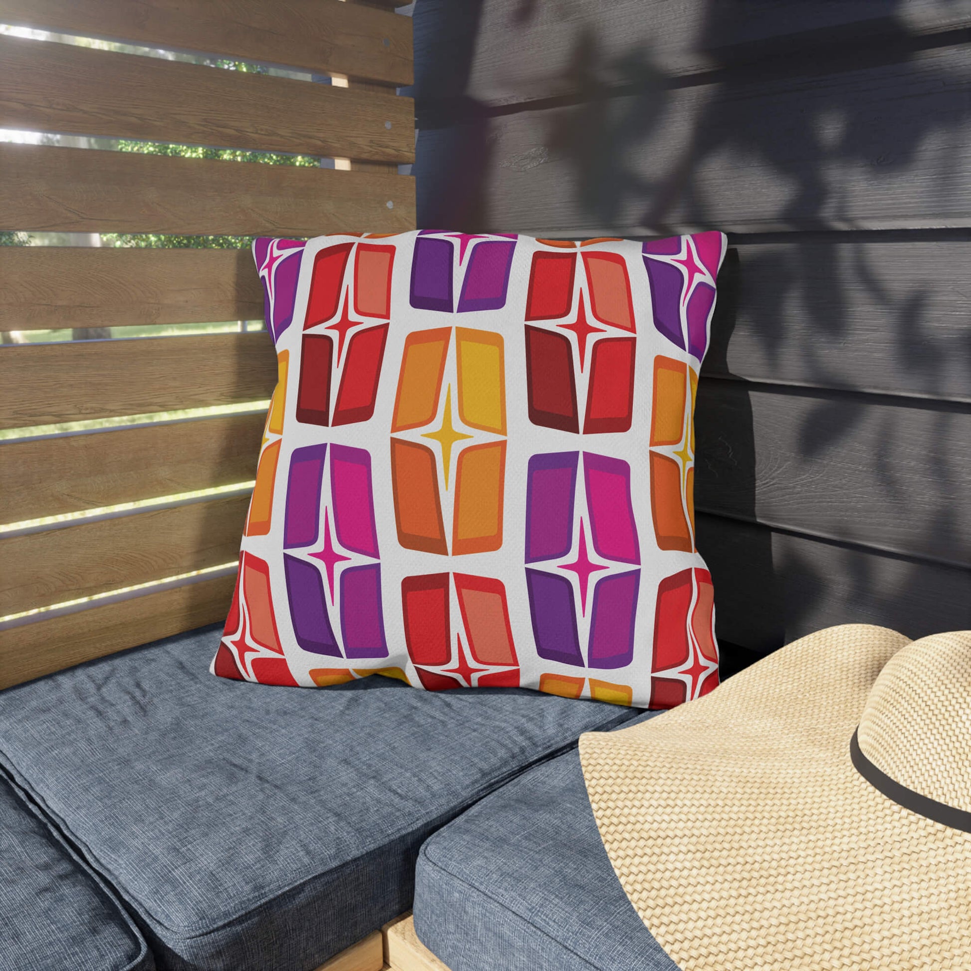 Mid Century Modern Orange Purple AstroShields 18" Square Outdoor Pillow on a bench