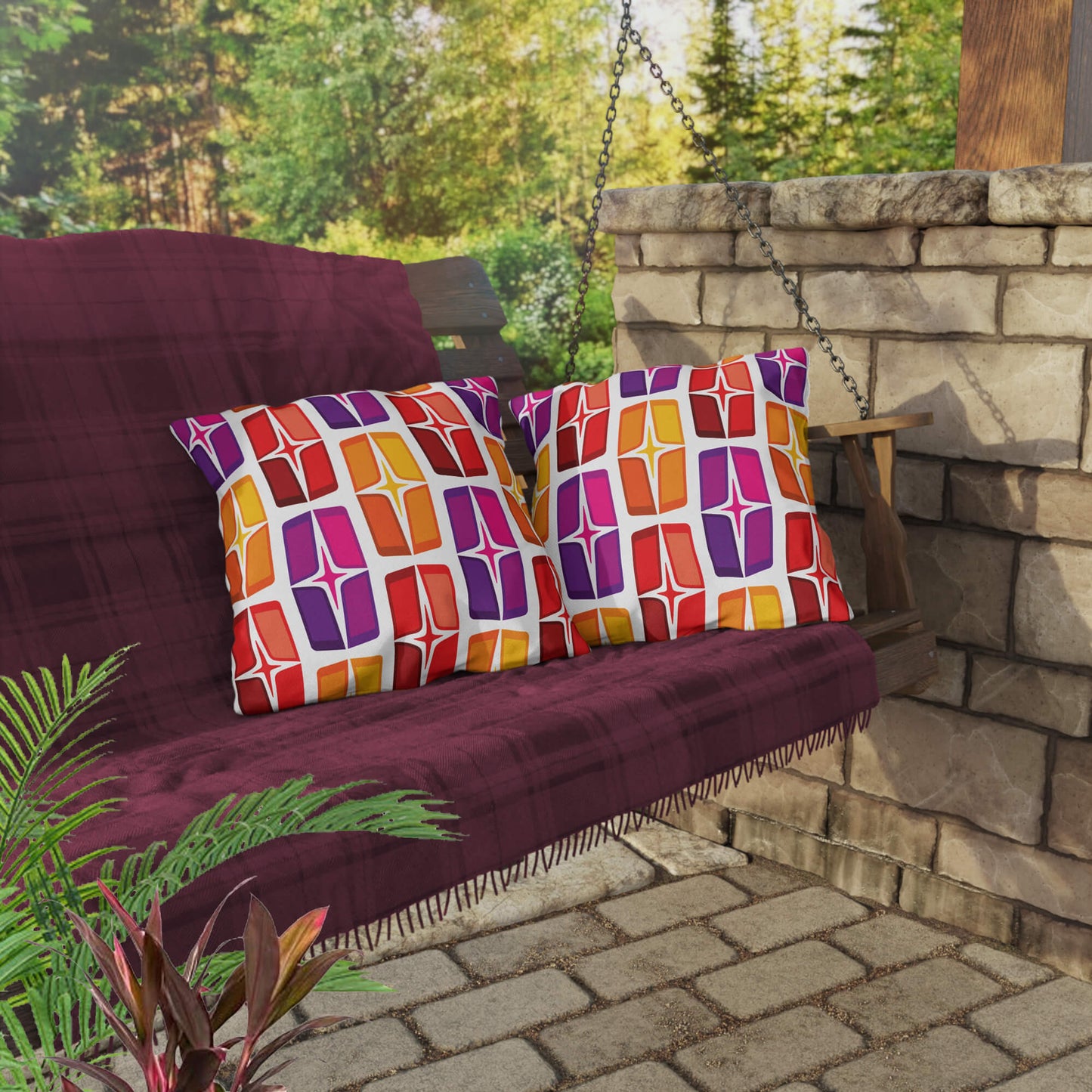 Mid Century Modern Orange Purple AstroShields 18" Square Outdoor Pillow on a swing bench