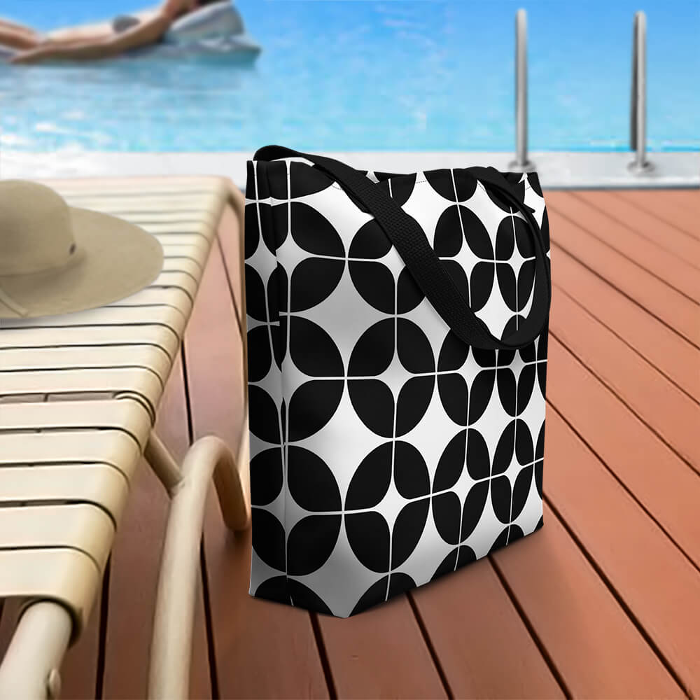 Mid Century Modern Black and White StarChips Beach Bag on a pool deck