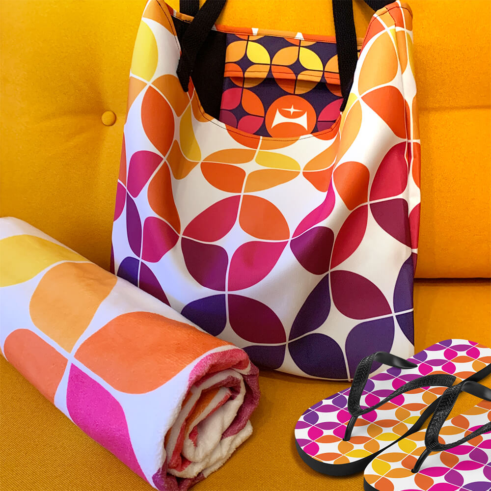 Mid Century Modern Purple Orange StarChips Beach Bag with matching towel and flip-flops on a sofa